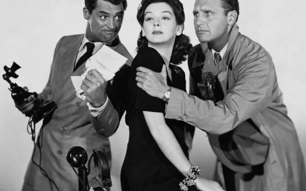 Black-and-white HD desktop wallpaper: film still from His Girl Friday — three actors in a tense newsroom pose, a woman flanked by two men, one holding a telephone.