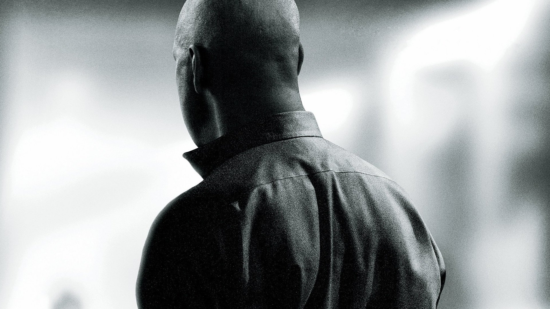 Rear view of a solitary man in a dark coat from The Equalizer movie, high-contrast black-and-white HD PC desktop wallpaper and background.