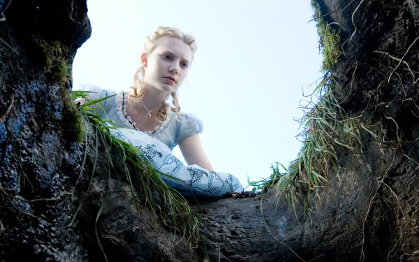 HD wallpaper of Mia Wasikowska as Alice from the 2010 movie Alice in Wonderland, seen from the bottom of a hole looking up at her.