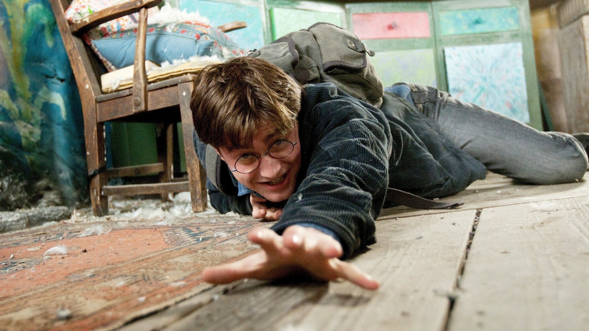 Daniel Radcliffe as Harry Potter reaching forward on the floor in a scene from Harry Potter and the Deathly Hallows: Part 1, featured in an HD PC desktop wallpaper.