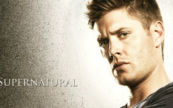 Dean Winchester, portrayed by Jensen Ackles, gazes intensely in this HD wallpaper from the TV show Supernatural, showcasing the show's dramatic style and character focus.