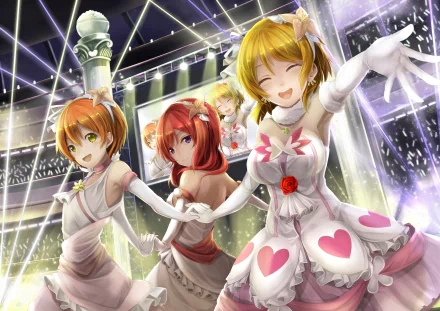 Three characters from Love Live!—Maki Nishikino, Hanayo Koizumi, and Rin Hoshizora—performing together on a vibrant stage, captured in a colorful HD anime wallpaper.