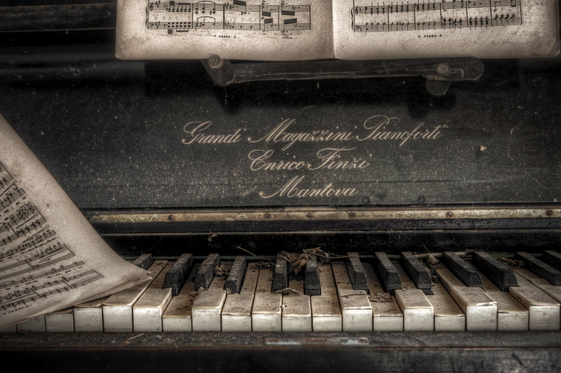 Close-up HD desktop wallpaper showing worn piano keys and aged sheet music on an old piano, capturing vintage musical charm and history.