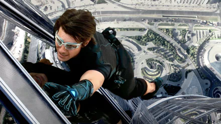 HD PC desktop wallpaper featuring Tom Cruise in a daring climbing scene from the movie Mission: Impossible - Ghost Protocol.