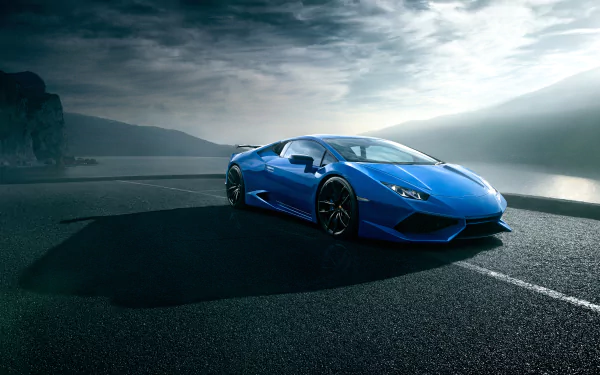 A blue Lamborghini Huracan supercar parked on a scenic coastal road under a cloudy sky, captured in 4K Ultra HD for a PC desktop wallpaper.