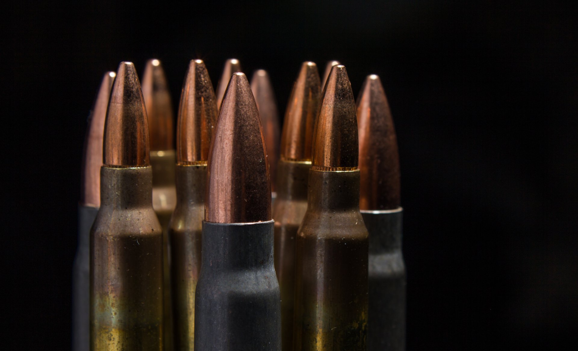 HD PC desktop wallpaper: close-up of man-made brass and copper bullets standing upright against a dark background.