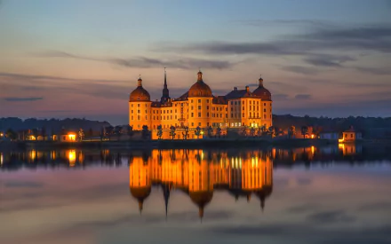 Moritzburg Castle at dusk in Germany, golden lights reflected on calm water — HD PC desktop wallpaper background of the man-made Baroque castle.