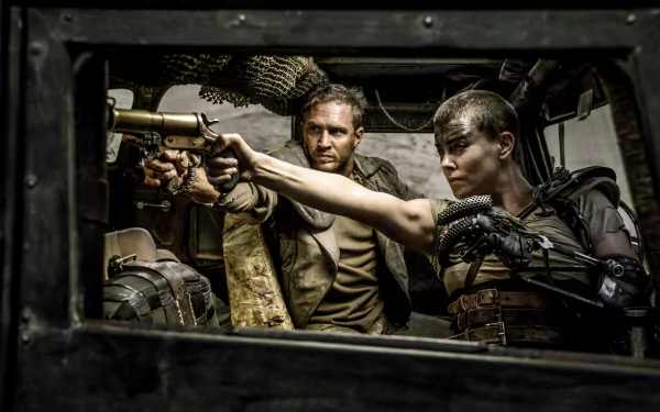 A thrilling scene from *Mad Max: Fury Road* featuring Imperator Furiosa (Charlize Theron) and Max (Tom Hardy) as they confront danger from within a vehicle.