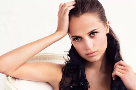 Alicia Vikander, a Swedish actress with brown eyes and brunette hair, poses elegantly in this HD desktop wallpaper, showcasing her striking features and captivating expression.