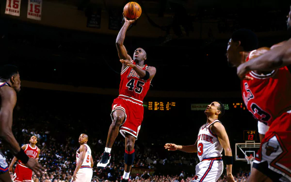 HD wallpaper of Michael Jordan in mid-air during a basketball game, wearing a Chicago Bulls jersey with the number 45.