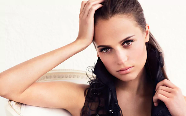 Alicia Vikander, a Swedish actress with brown eyes and brunette hair, poses elegantly in this HD desktop wallpaper, showcasing her striking features and captivating expression.