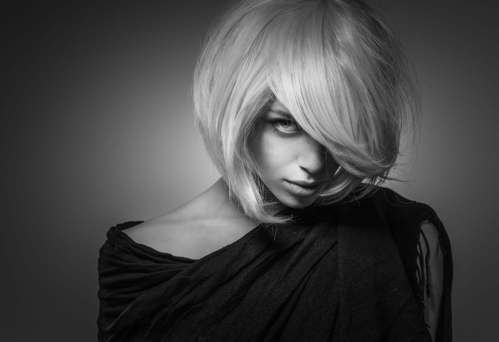 Black and white HD desktop wallpaper featuring a blonde woman model with an intense stare, partially covered by shadows and her hair.