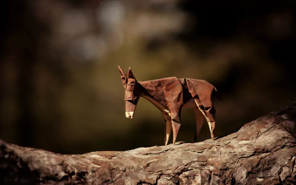 A man-made origami donkey stands on a tree branch with a soft bokeh background, captured in 4K Ultra HD for a detailed desktop wallpaper.