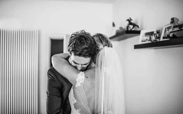 Black and white 4K Ultra HD image of a bride and groom embracing, capturing a tender moment of love and intimacy in wedding photography.