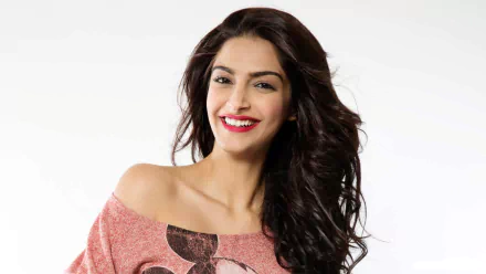 HD desktop wallpaper of a smiling Indian actress with brown eyes, brunette hair, and red lipstick.