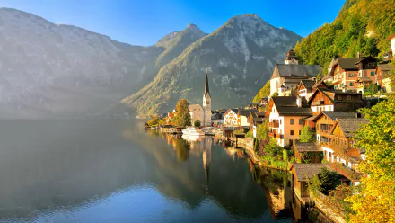 Scenic 4K Ultra HD view of Hallstatt, Austria, featuring a peaceful lake, mountain backdrop, quaint houses, and a church reflecting in the water.