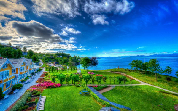 Vibrant HDR desktop wallpaper featuring a colorful tropical resort with hotel buildings, palm trees, manicured gardens, and ocean views under a partly cloudy sky.