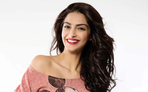 HD desktop wallpaper of a smiling Indian actress with brown eyes, brunette hair, and red lipstick.