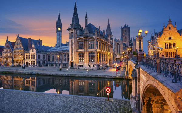 A stunning night view of a Belgium town, featuring a bridge and charming houses reflected in the river under soft lighting, showcasing man-made beauty and serene waterways.