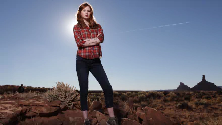 HD desktop wallpaper featuring Karen Gillan as Amy Pond from the TV show Doctor Who (2005), standing confidently in a desert landscape under a clear blue sky.