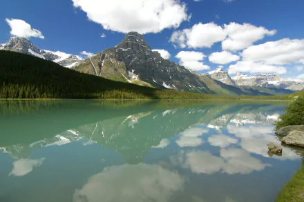 HD desktop wallpaper of Mount Chephren in Banff National Park, Alberta, Canada: mountain and forest reflected in a turquoise lake under clouds and blue sky.