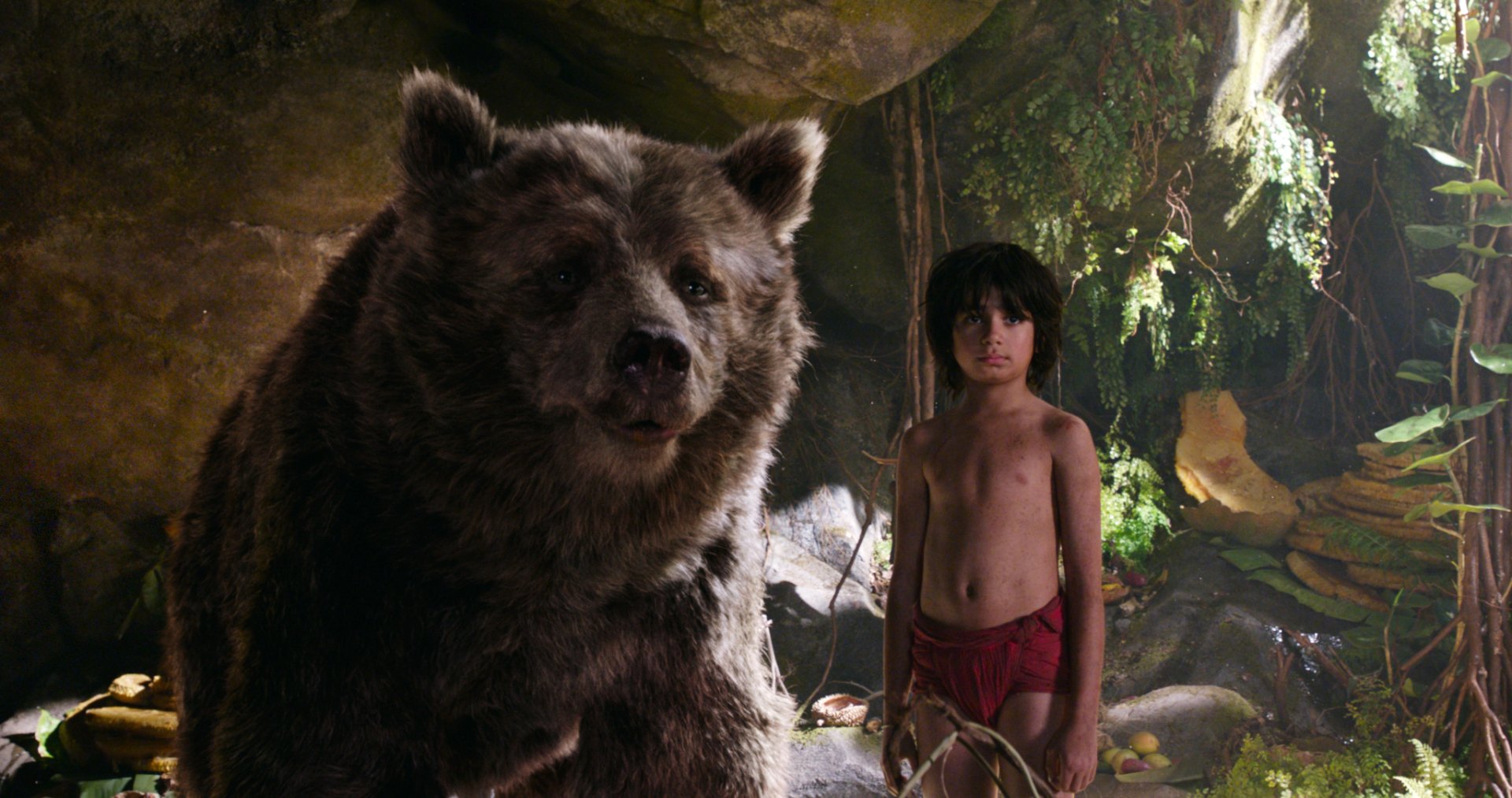 HD PC desktop wallpaper featuring a scene from the movie The Jungle Book (2016) with Mowgli standing beside the bear Baloo in a lush jungle setting.