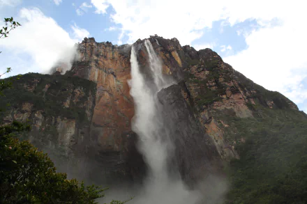 A stunning view of Angel Falls in Venezuela, showcasing a majestic waterfall cascading down a cliff surrounded by lush greenery and dramatic mountain scenery.