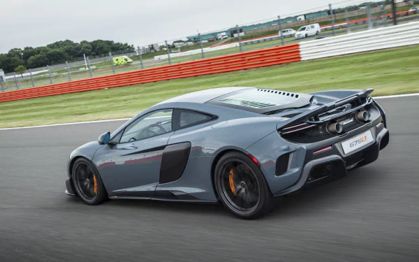 McLaren 675LT supercar in motion on a racetrack, showcased in a sharp 4K Ultra HD desktop wallpaper capturing the sleek design and performance of this luxury vehicle.