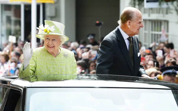 A vibrant HD wallpaper featuring Queen Elizabeth II smiling and waving from a car, with crowds gathered in celebration, accompanied by Prince Philip.