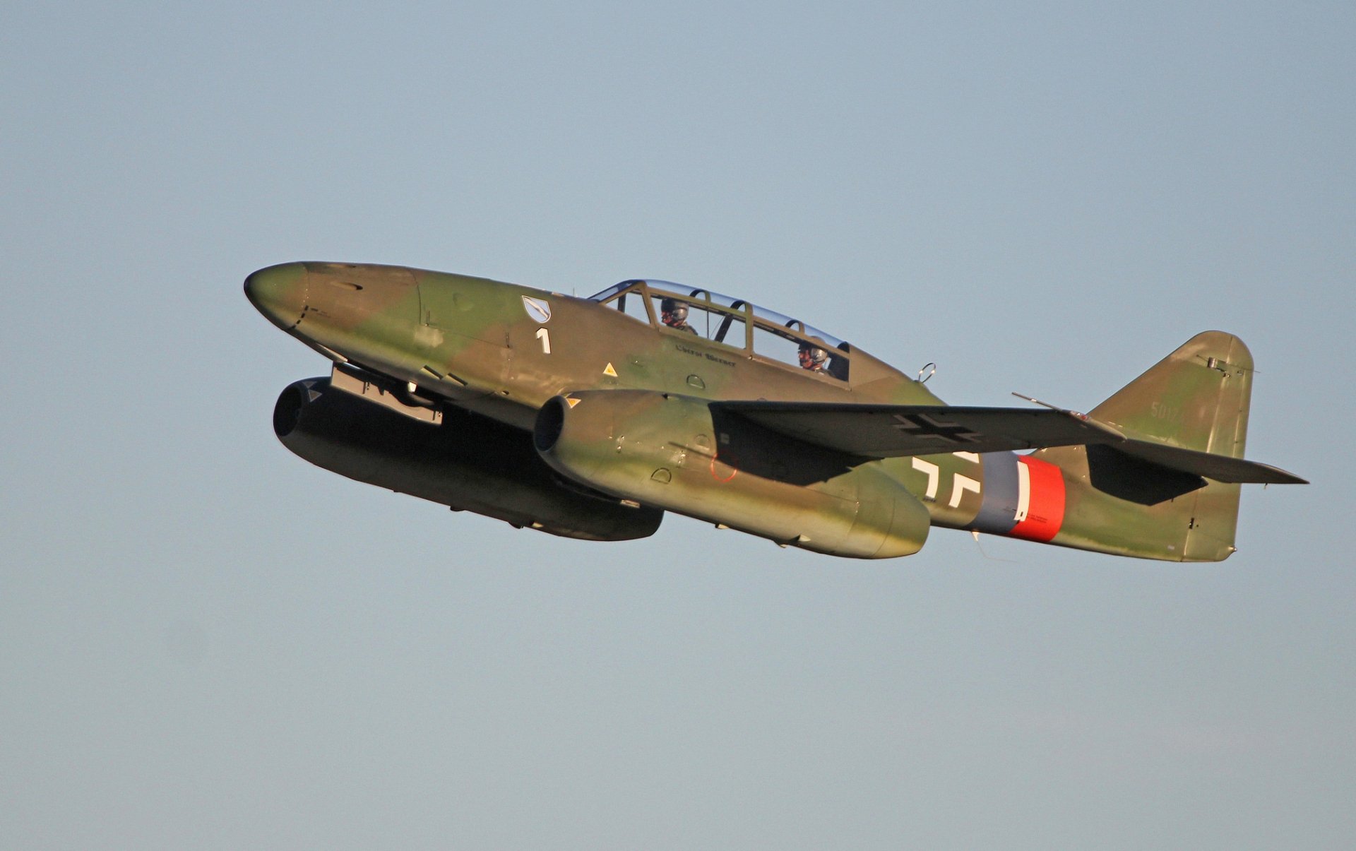 A Messerschmitt Me 262 warplane in flight, showcasing its distinctive military design. This high-definition image serves as a striking desktop wallpaper and background.