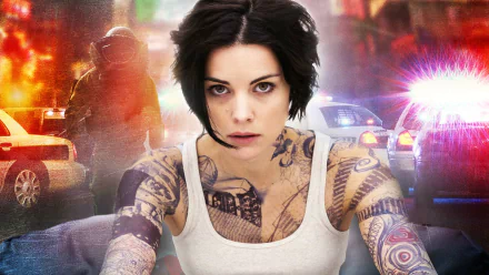 HD desktop wallpaper featuring Jaimie Alexander as the tattooed lead character from the TV show Blindspot, set against a backdrop of police lights and action.