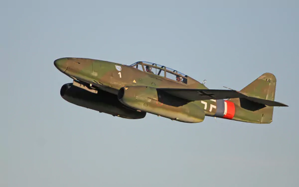 A Messerschmitt Me 262 warplane in flight, showcasing its distinctive military design. This high-definition image serves as a striking desktop wallpaper and background.