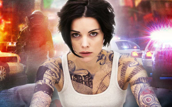 HD desktop wallpaper featuring Jaimie Alexander as the tattooed lead character from the TV show Blindspot, set against a backdrop of police lights and action.