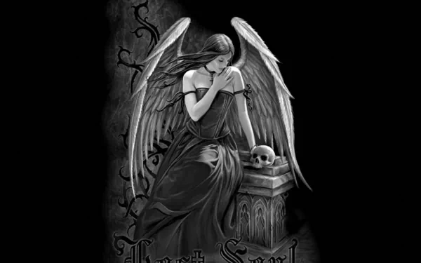 A gothic angel with large wings sits pensively beside a gravestone, holding a skull, embodying a dark fantasy aesthetic. This HD wallpaper creates a hauntingly beautiful atmosphere.