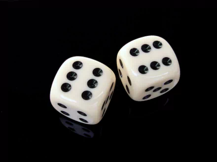 Two ivory dice with black dots sit on a reflective black surface, creating a striking visual. This HD image serves as an engaging PC desktop wallpaper or background.