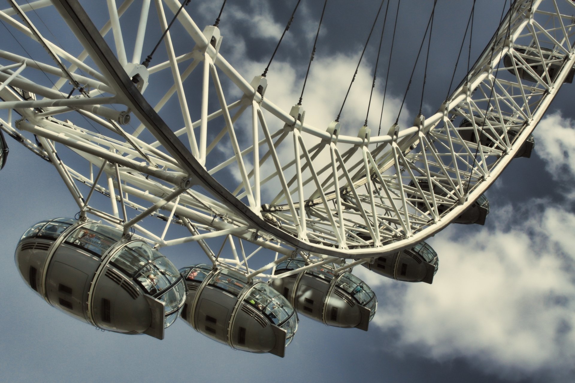 Close-up of the man-made London Eye ferris wheel, glass passenger capsules and steel spokes framed against a cloudy sky — 4K Ultra HD PC desktop wallpaper.