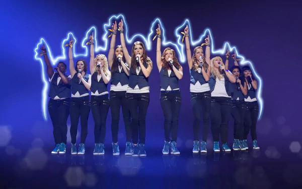 HD desktop wallpaper featuring the a cappella group from the movie Pitch Perfect 2 performing on stage with vibrant blue lighting and energetic poses.