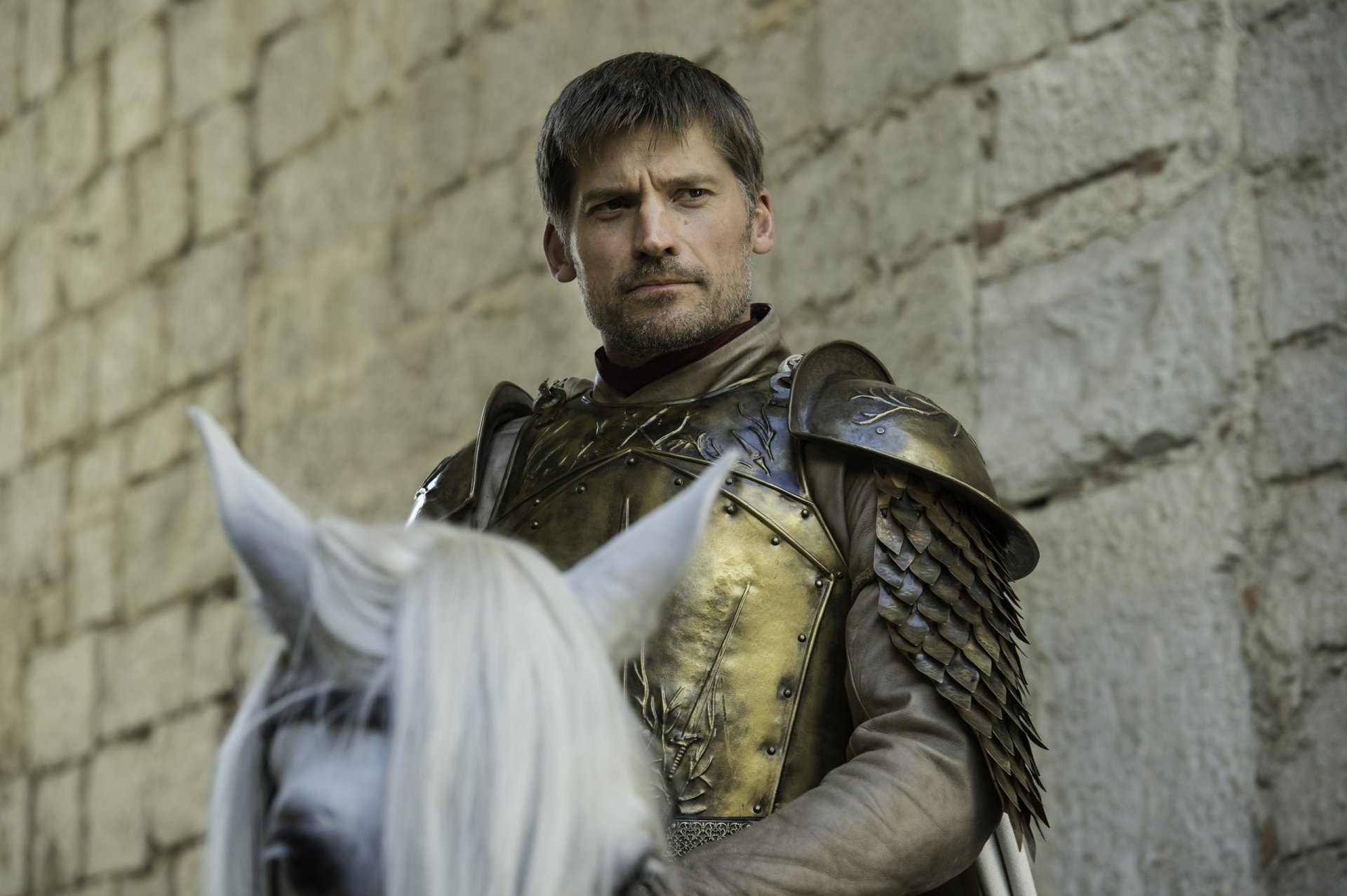 Jaime Lannister in golden armor on horseback by a stone wall — Game of Thrones TV show 2K Quad HD desktop wallpaper.