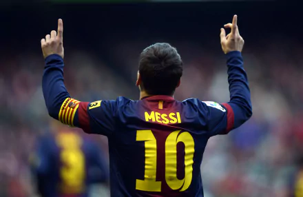 Lionel Messi celebrates a goal, wearing the number 10 jersey and raising his arms, captured in an HD sports desktop wallpaper background.