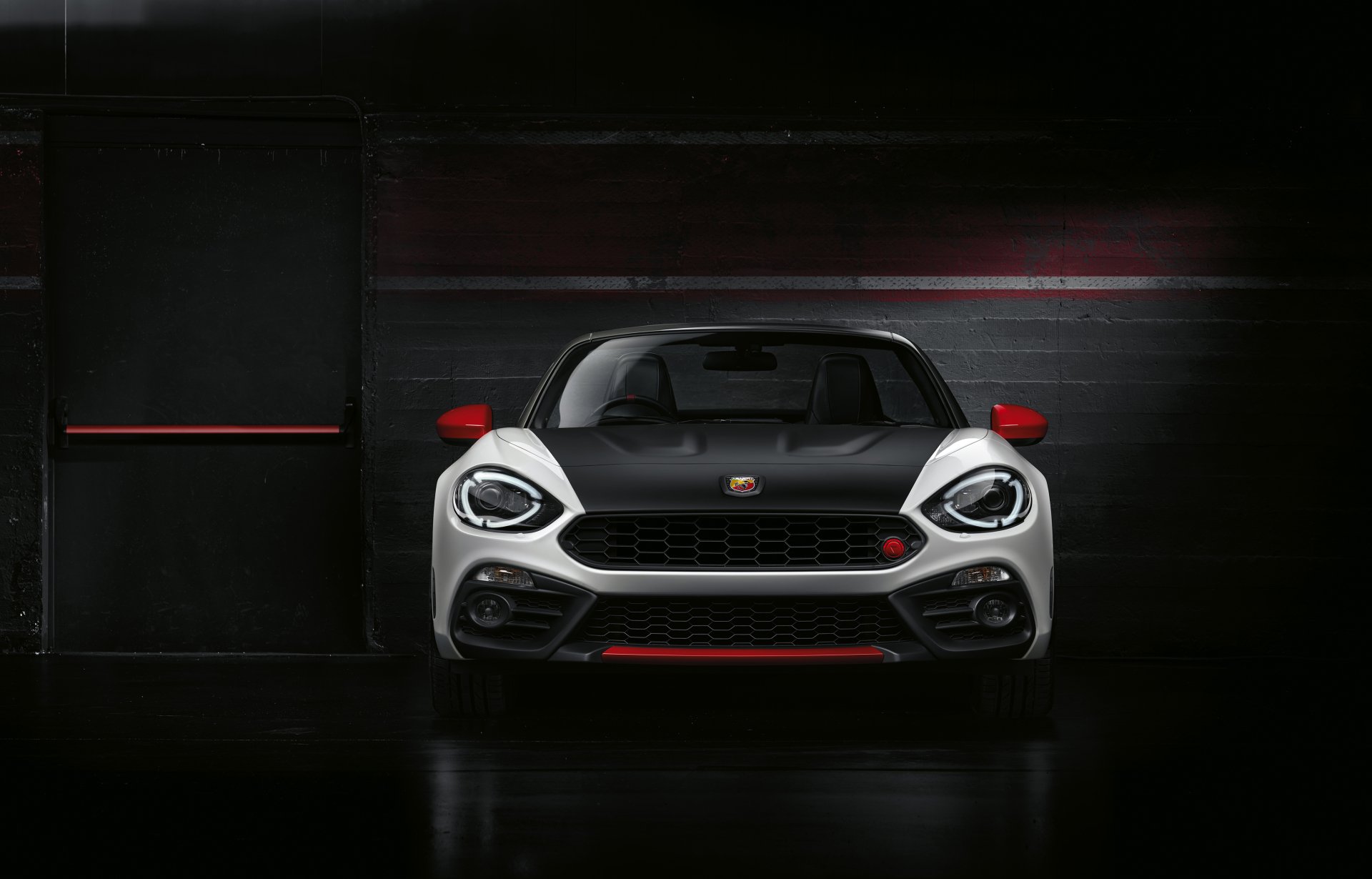 Front view of a white Fiat 124 Spider vehicle with red accents in a dark garage — high-contrast 4K Ultra HD PC desktop wallpaper/background.