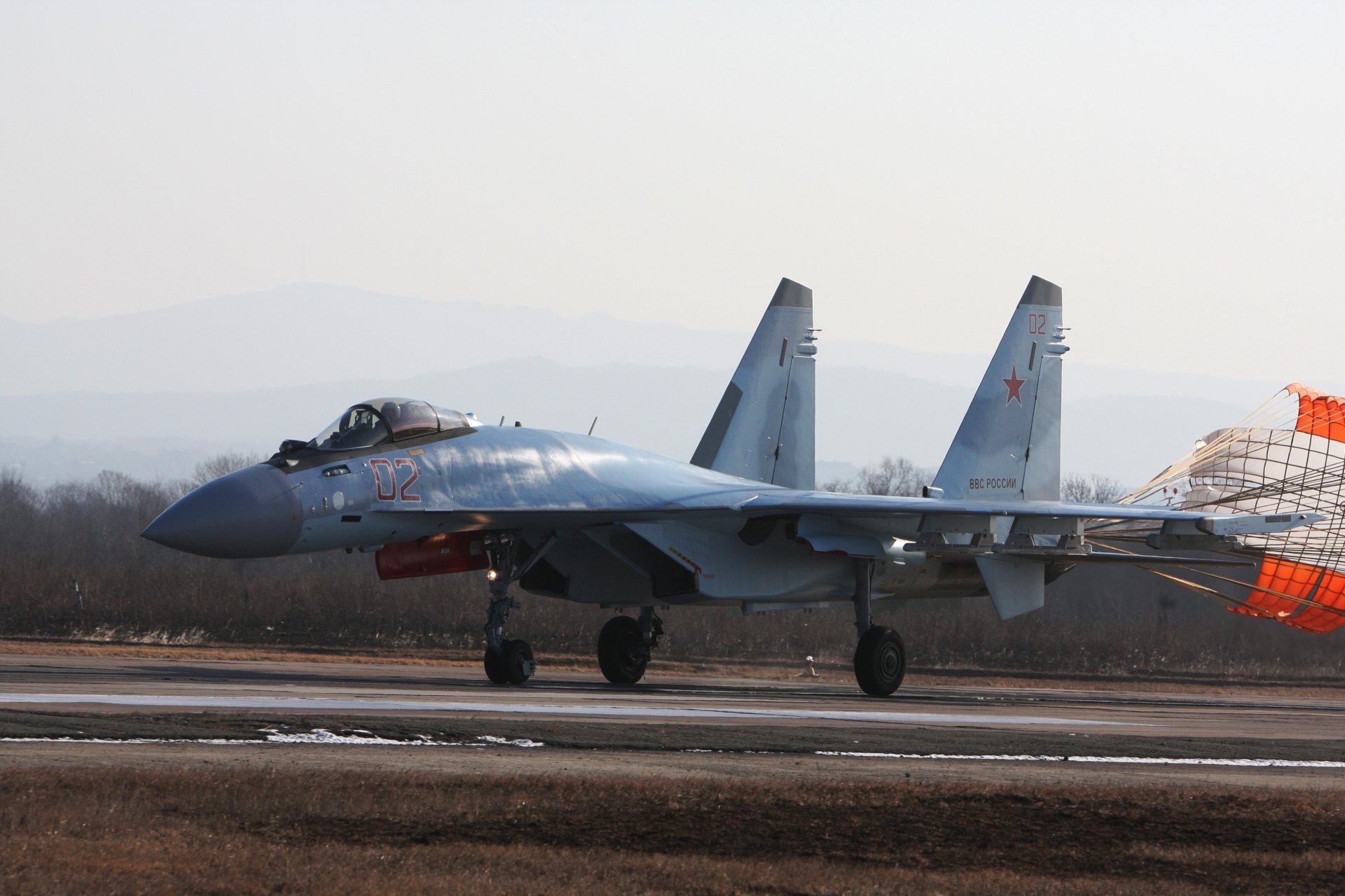 A Sukhoi Su-35 military jet fighter from the air force lands on a runway, shown in a high-resolution 4K Ultra HD desktop wallpaper and background.