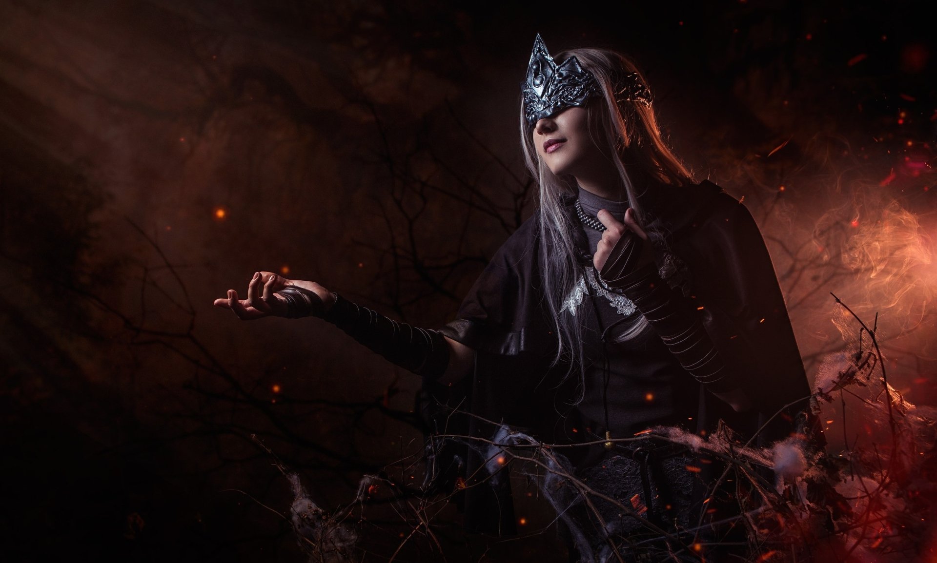 HD PC wallpaper featuring a woman cosplaying Fire Keeper from Dark Souls III, set against a dark, fiery background with glowing embers.