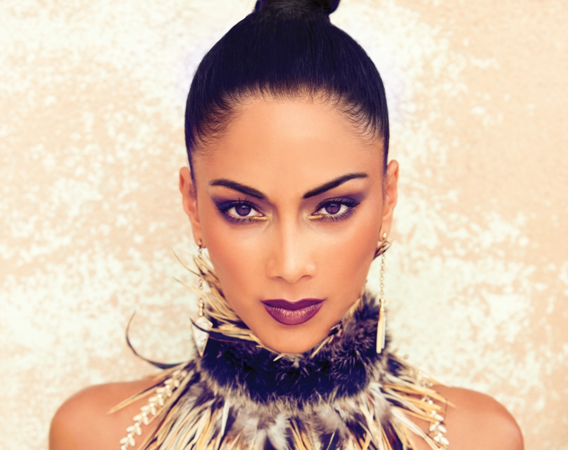 Close-up HD portrait of American singer Nicole Scherzinger with brunette hair, brown eyes, bold lipstick, and statement earrings against a textured background.