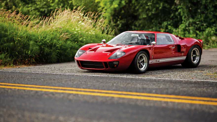 Red Ford GT40 supercar vehicle parked on a roadside with lush green background — 4K Ultra HD PC desktop wallpaper.