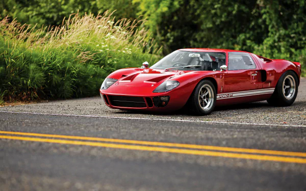 Red Ford GT40 supercar vehicle parked on a roadside with lush green background — 4K Ultra HD PC desktop wallpaper.