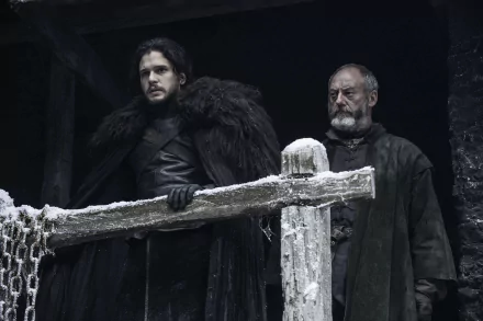 Jon Snow and Davos Seaworth on a snow-dusted wooden battlement, cloaked in black furs, brooding in a dark Game of Thrones 4K desktop wallpaper.