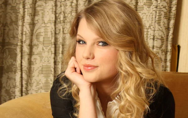 HD desktop wallpaper featuring a close-up portrait of American singer Taylor Swift with blonde hair, posing thoughtfully in a warm indoor setting.