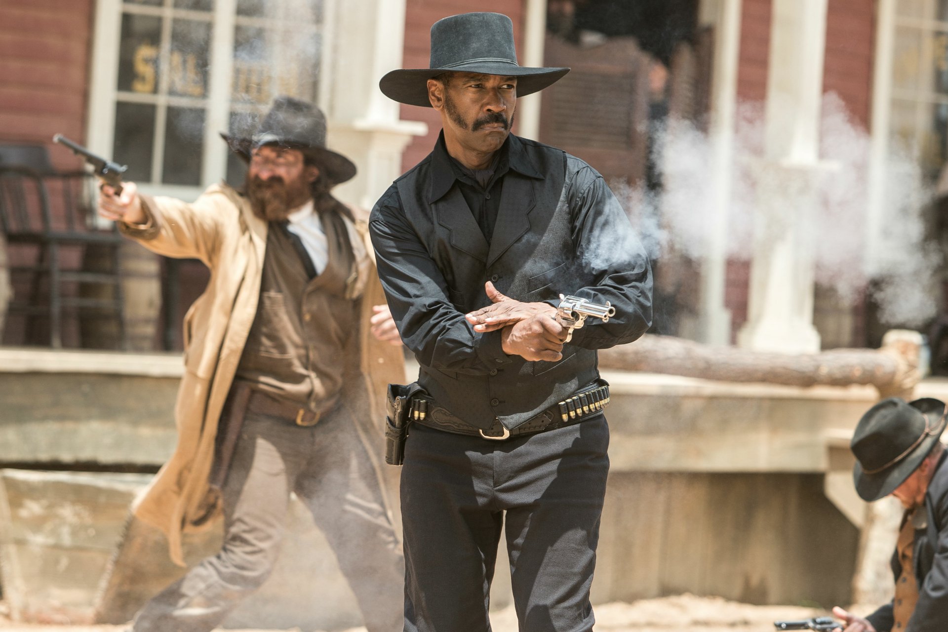 HD PC desktop wallpaper featuring Denzel Washington as a gunslinger in the 2016 movie The Magnificent Seven, set in a smoky Western town showdown.