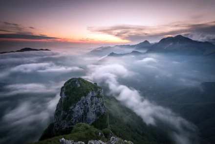 2K Quad HD PC desktop wallpaper: panoramic mountain landscape at the horizon, clouds and fog rolling through valleys under a pastel sky, serene nature view.