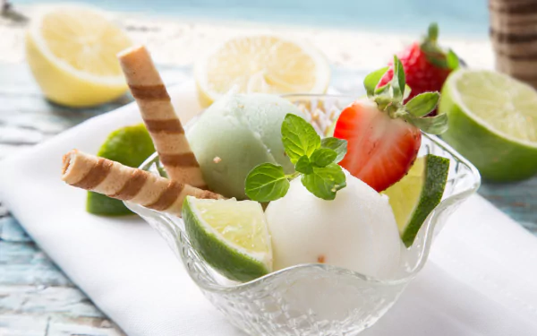 A vibrant 4K Ultra HD wallpaper featuring a refreshing summer dessert of lime and vanilla ice cream garnished with fresh strawberries, lime wedges, mint leaves, and wafer sticks.